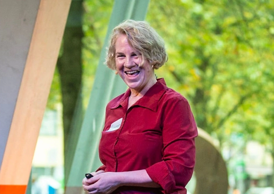 Yvonne Behnke lacht auf der Bühne, mit einem Präsentationsklicker in der Hand.