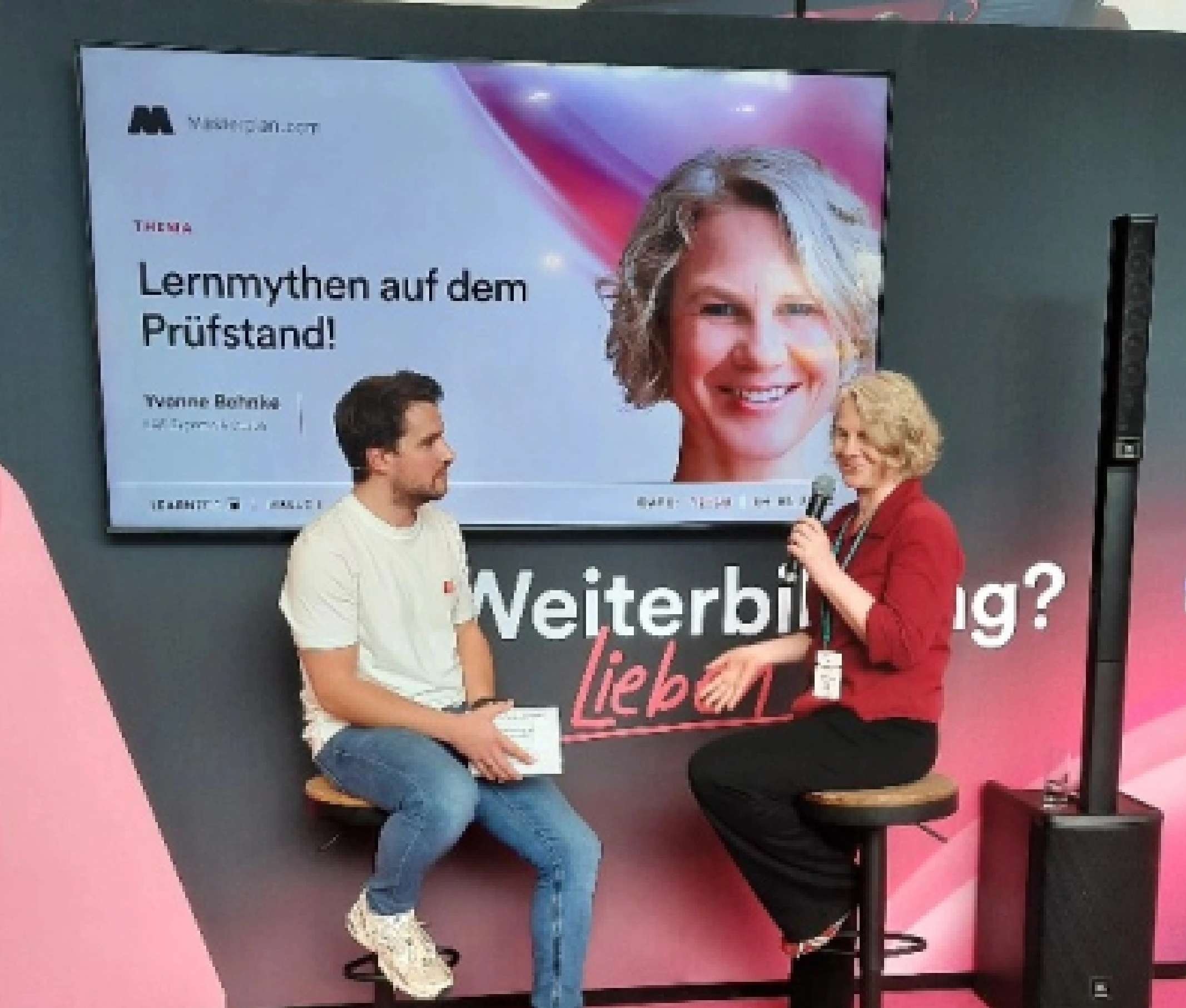 Yvonne Behnke im Gespräch mit Mikrofon am Masterplan-Stand auf der Learntec.